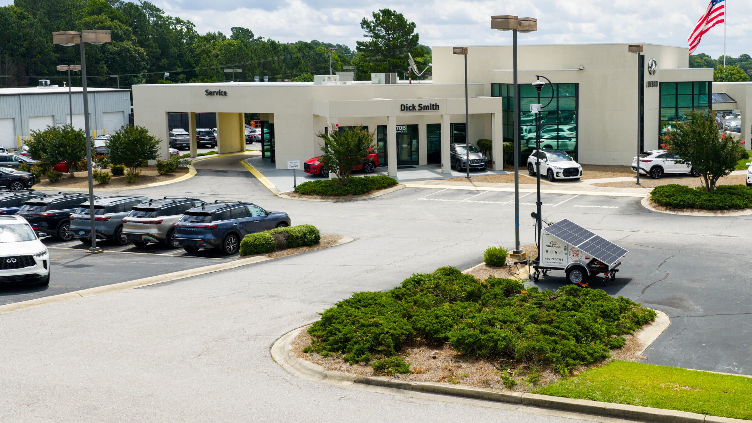 Aerial view of a Sharpvue MAST mobile surveillance trailer deployed at a car dealership.